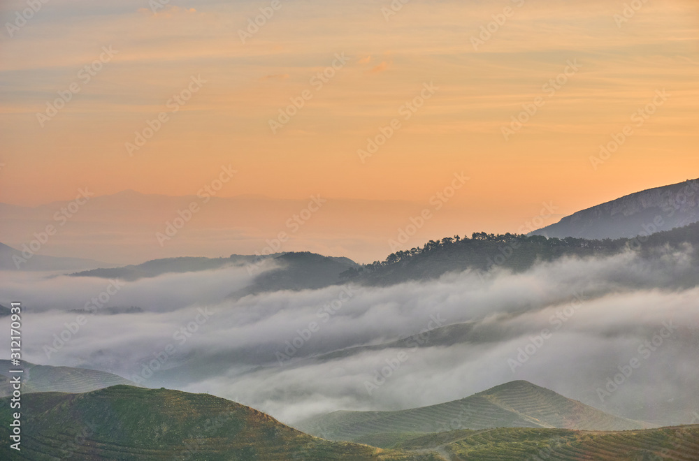 Beautiful Sunrise over Clouds and Mountains