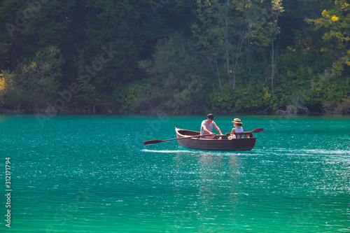 man and woman on a boat sailing in a blue lake
