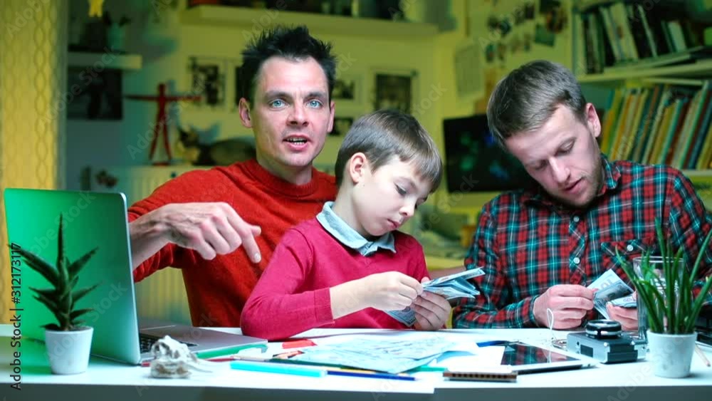 Two guys and a schoolboy are counting the money won in the lottery. Two guys and a schoolboy are counting the money won in the lottery.