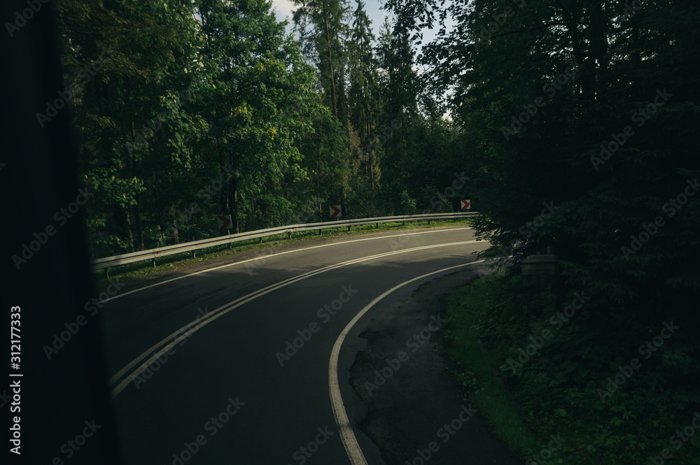 View from the window of a tourist bus turning on a mountain road. Background Mountain road with turns.