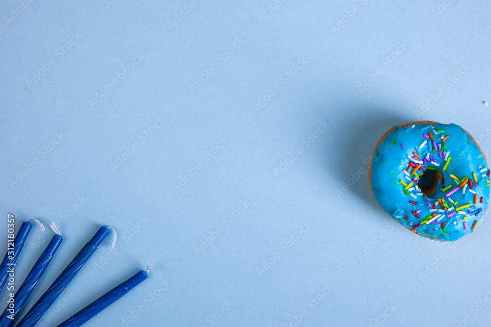 Fotografie colorful doughnut candels blue background studio