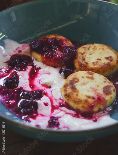  Close up oroginal russian food style greek cheese pancakes with yogurt and fruit jam photo