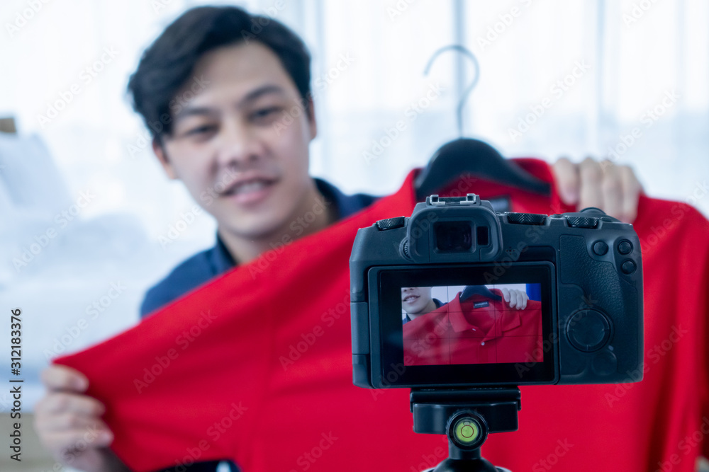 Asian young man blogger present and review product video broadcast live stream video to a social network. blogging, video blog, vlogging, online shopping, and social media concept