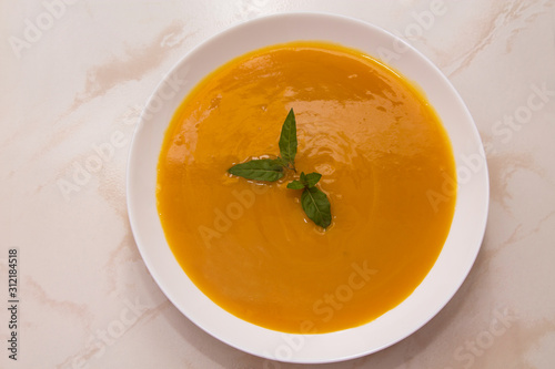 bowl with pumpkin soup on background