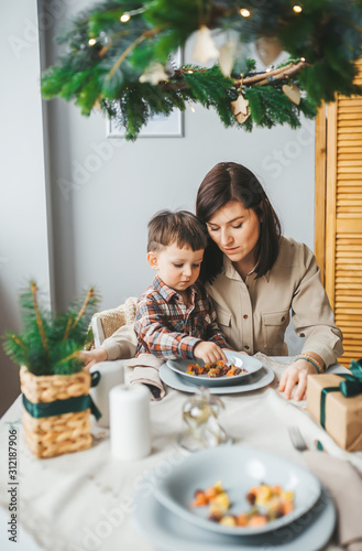 Young happy mother and her child eating healthy breakfast