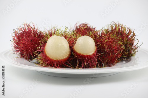 Selective focus red Rambutans fruit on white plate on white background