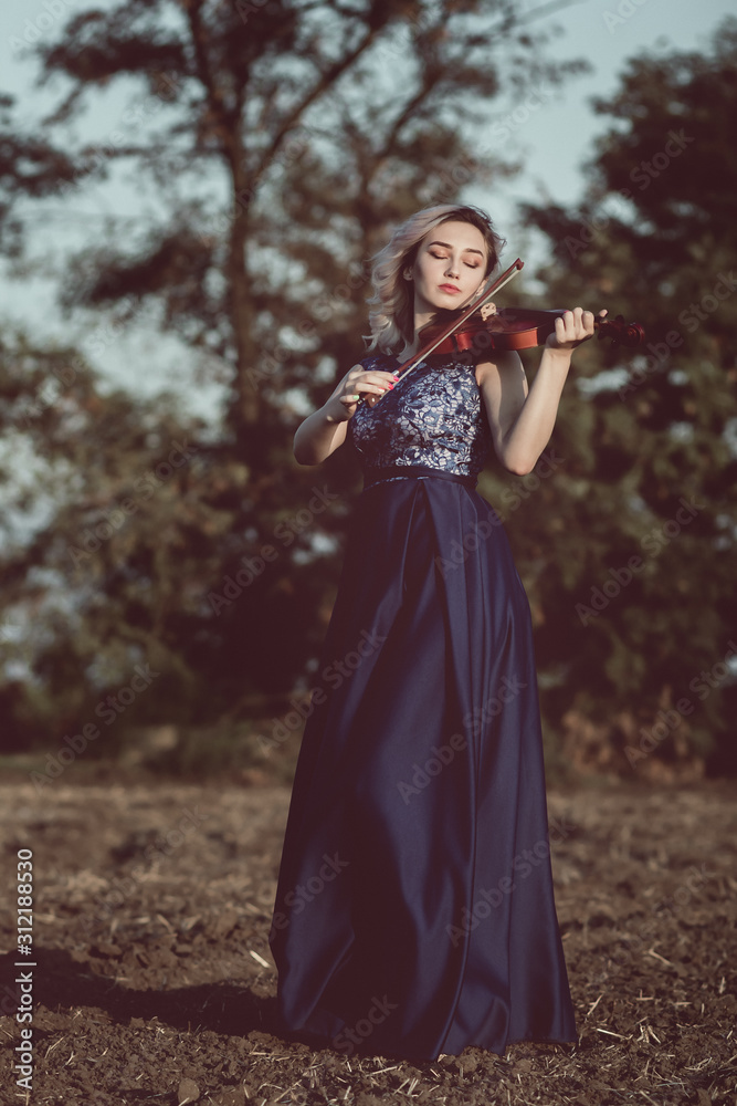 face of a beautiful girl with a violin under her chin outdoors, young woman playing a musical instrument on nature in solitude, concept music and feelings face of a beautiful girl with a violin under her chin outdoors, young woman playing a musical instrument on nature in solitude, concept music and feelings