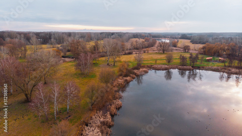 Drone shot of cozy little lake with beautiful colors in the middle of lake on an island