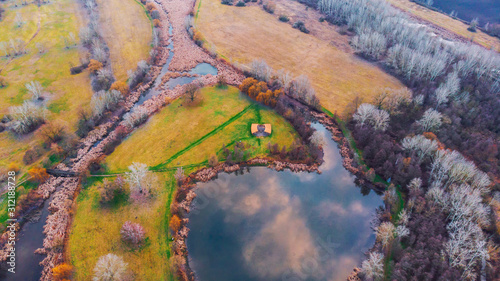 Drone shot of cozy little lake with beautiful colors in the middle of lake on an island