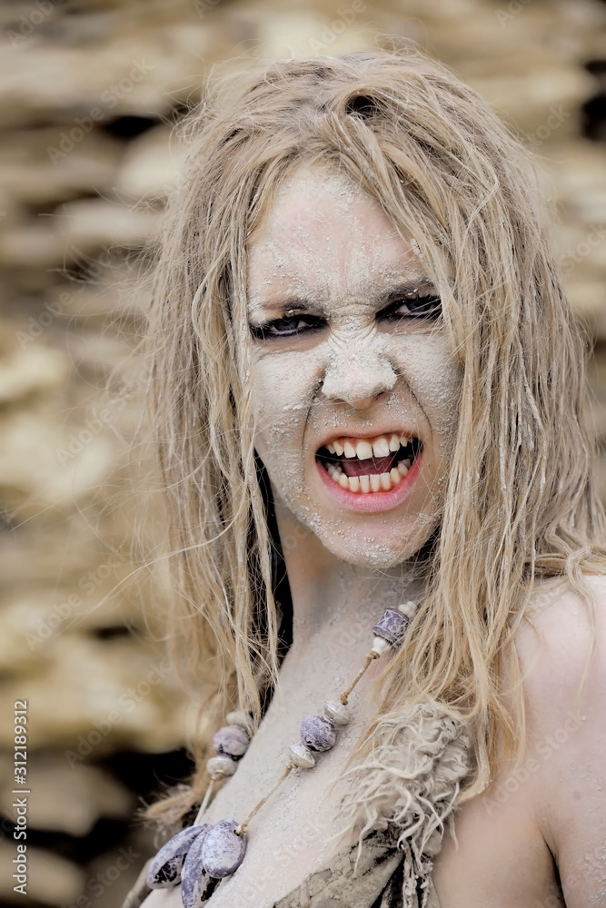 A young woman's face is covered with dirt and filth. Her hair is