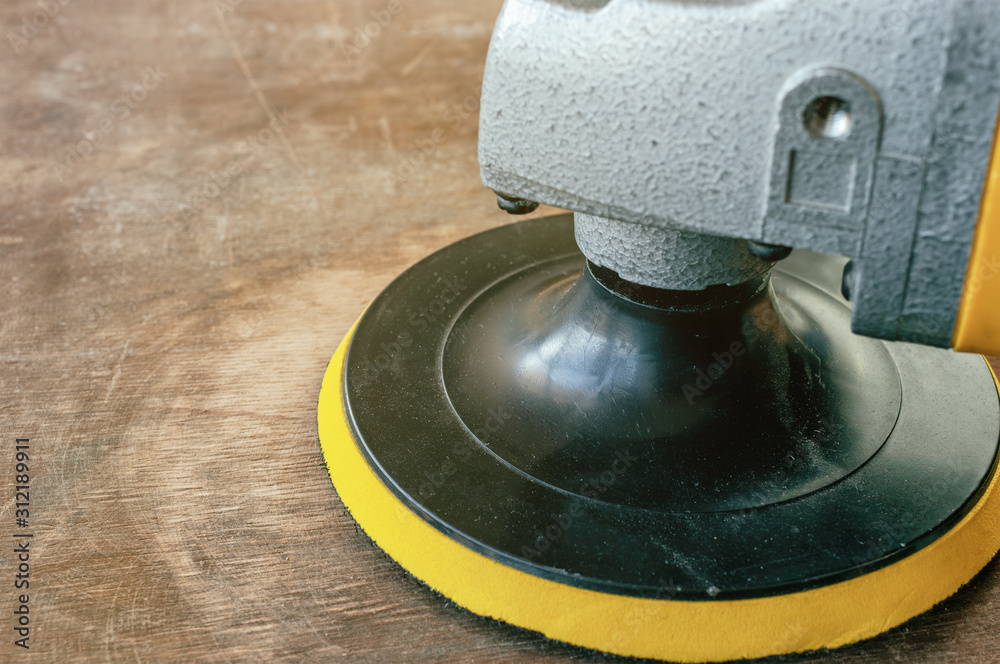 Sander machine on wooden background.