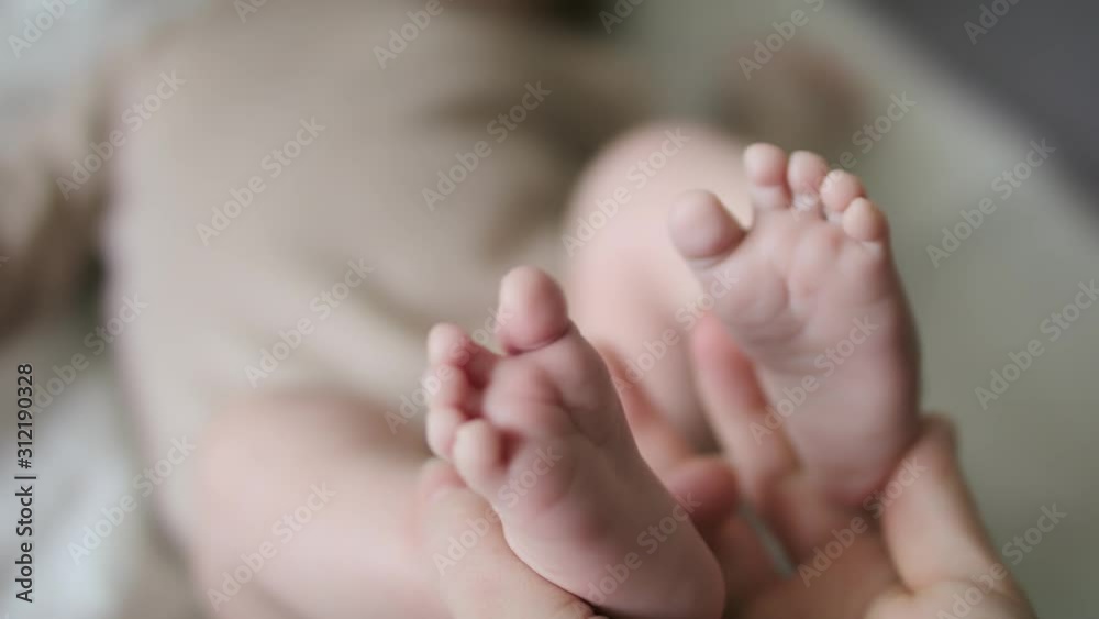 Touching baby feet softly with tender love in slow motion closeup Touching baby feet softly with tender love in slow motion closeup