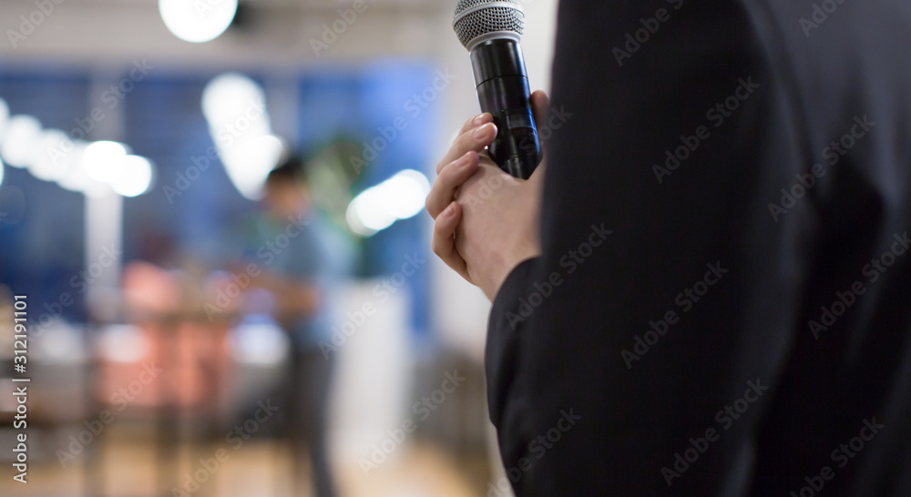 Speaker giving a talk at a corporate business conference. Audience in hall with presenter in front of presentation screen. Corporate executive giving speech during business and entrepreneur seminar. Speaker giving a talk at a corporate business conference. Audience in hall with presenter in front of presentation screen. Corporate executive giving speech during business and entrepreneur seminar.