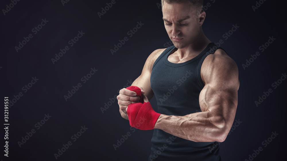 Man is wrapping hands with red boxing wraps Man is wrapping hands with red boxing wraps