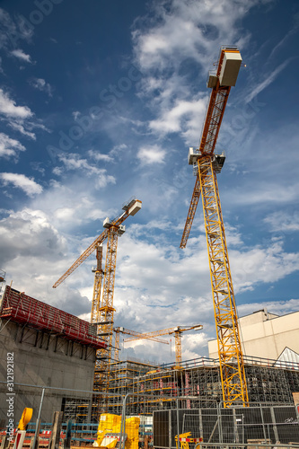 Day view of the construction site with cranes and building. Vertical view