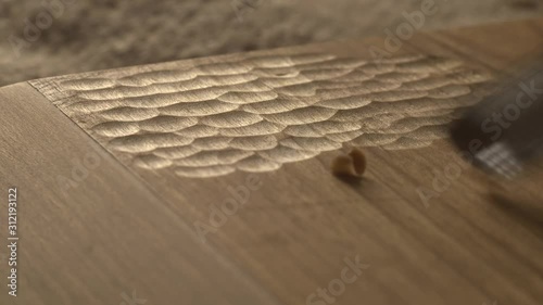 woodcarver carves a chisel notch in the board