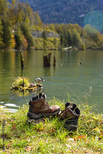 Trekking boots near the lake with mountains