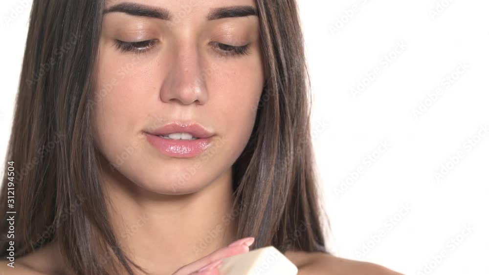 Portrait shot of a charming young woman gently touching her face with a bar of soap. Skincare concept Portrait shot of a charming young woman gently touching her face with a bar of soap. Skincare concept