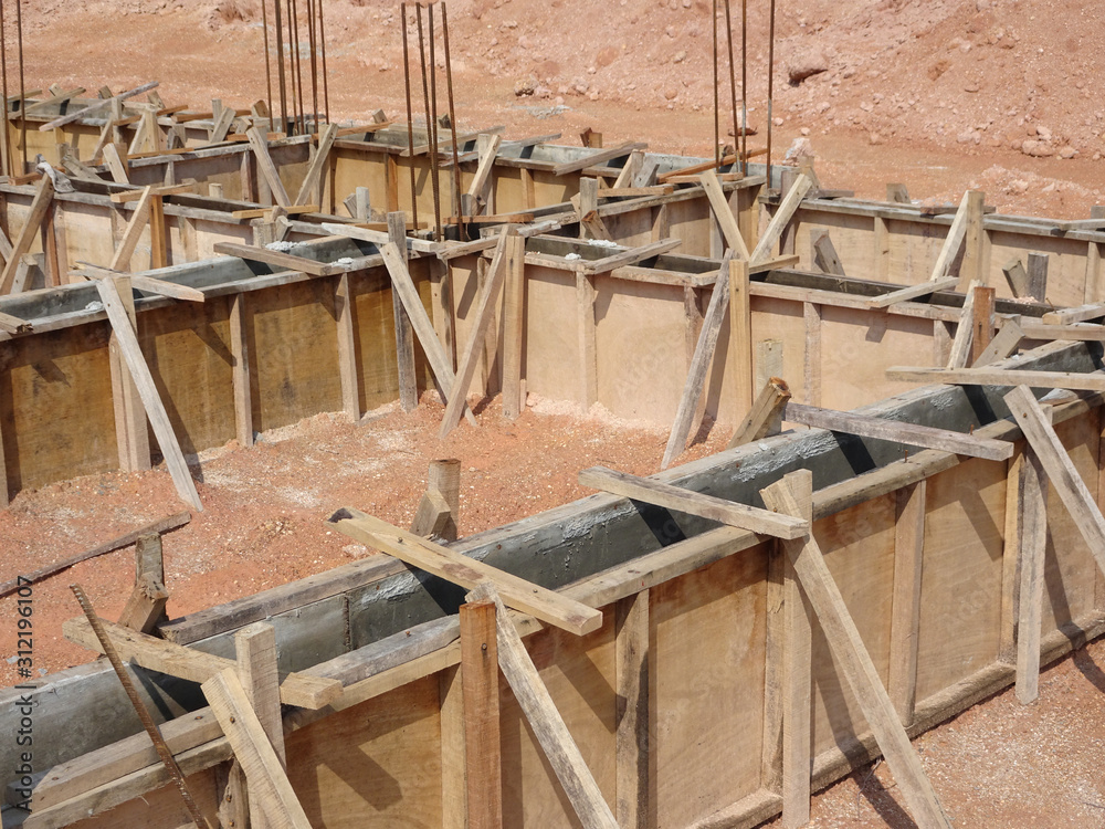Building ground beam under construction using temporary timber plywood at the site. Reinforced by the reinforcement steel to strengthen the structure. Building ground beam under construction using temporary timber plywood at the site. Reinforced by the reinforcement steel to strengthen the structure.