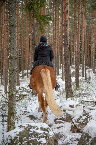 Woman horseback riding in winter