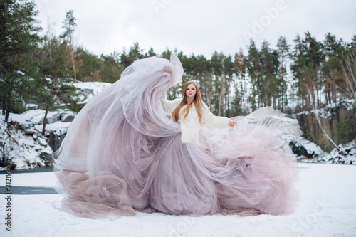 Fototapeta Blonde woman in waving dress in winter outdoors