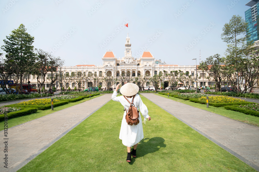 Φωτογραφία Woman tourist is traveling and sightseeing at Hochiminh people's committee hall landmark of Saigon, Vietnam