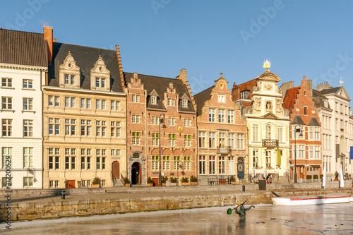 Row of typical Gothic houses on Korenlei quay along ice covered Leie river in winter, Ghent, Belgium