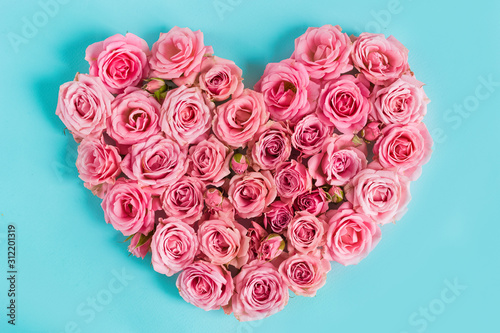 Beautiful heart made of beautiful pink roses on a blue background. I love you. Greeting card