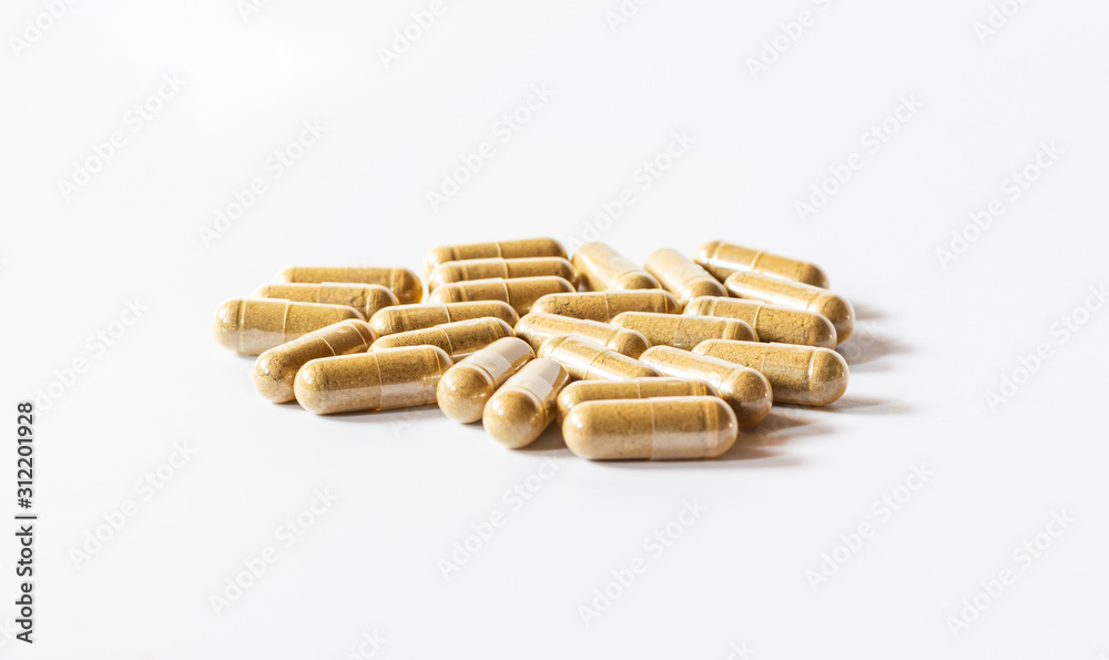 Brown herbal capsules on a white background and hard light Brown herbal capsules on a white background and hard light