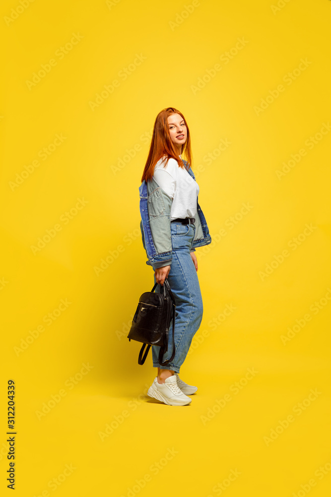 It's easier to be follower. Need minimum clothes to go. Caucasian woman's portrait on yellow background. Beautiful female red hair model. Concept of human emotions, facial expression, sales, ad. It's easier to be follower. Need minimum clothes to go. Caucasian woman's portrait on yellow background. Beautiful female red hair model. Concept of human emotions, facial expression, sales, ad.