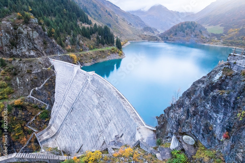 Reservoir lake and water dam in French Alps to produce hydroelectricity, sustainable development using renewable energy and hydropower photo