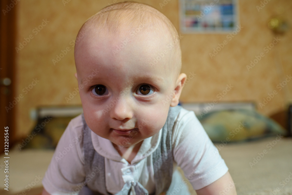 A small child plays on the bed at the parents. Happy childhood. A small child plays on the bed at the parents. Happy childhood.