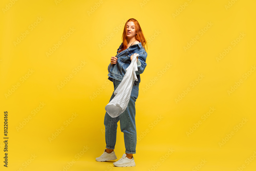 It's easier to be follower. Laundry faster, if it's only one shirt. Caucasian woman's portrait on yellow background. Beautiful red hair model. Concept of human emotions, facial expression, sales, ad. It's easier to be follower. Laundry faster, if it's only one shirt. Caucasian woman's portrait on yellow background. Beautiful red hair model. Concept of human emotions, facial expression, sales, ad.