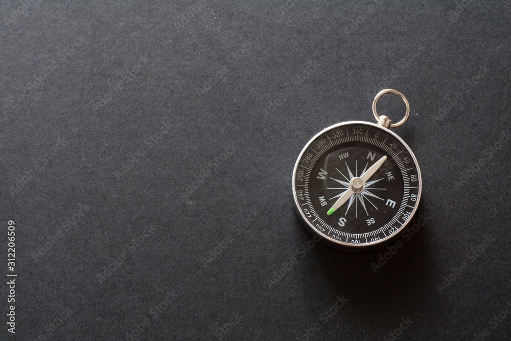 Compass on black paper background
