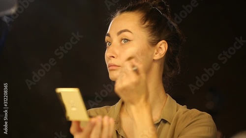 Caucasian woman apllying powder on her face photo