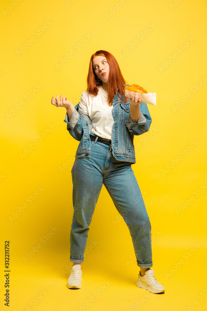 It's easier to be follower. Don't need to take photo with food. Caucasian woman's on yellow background. Beautiful female red hair model. Concept of human emotions, facial expression, sales, ad. It's easier to be follower. Don't need to take photo with food. Caucasian woman's on yellow background. Beautiful female red hair model. Concept of human emotions, facial expression, sales, ad.