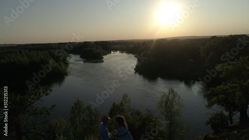 Guy and girl having fun at sunset. Aerial photo