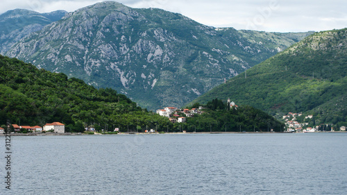 panoramic view from the ship to Kotor bay and the surrounding mountains, blue sky with white clouds, Montenegro