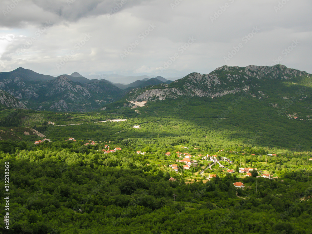 Obraz premium panoramic view from the observation deck in the mountains to the Skadar lake and green valley, blue sky, white clouds, Montenegro