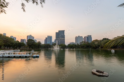 Landscape of the tall building with water reflaction at Lumpini park , Bangkok , Thailand.  The Building in capital of Thailand with sunset at Lumpini park.