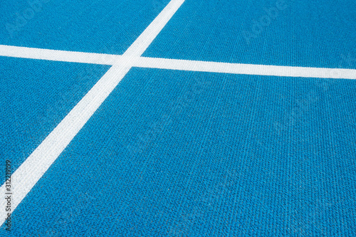Sport background. Blue running track with white lines in sport stadium. Top view