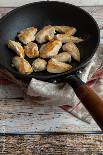 Roasted chicken breast in antique looking frying pan