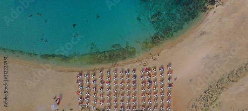 Aerial drone ultra wide photo of tropical exotic organised with sun beds sandy bay with turquoise sea