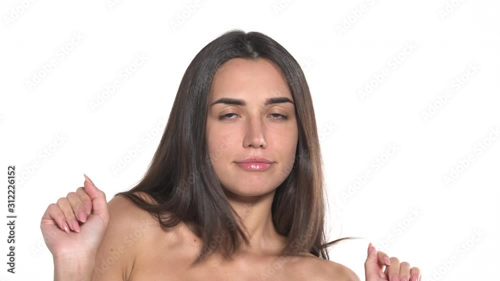 Portrait shot of a female model with naked shoulders posing to the camera. Woman is dancing. Professional model. Fashion concept