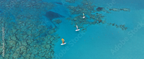 Aerial drone ultra wide photo of wind surfers practising in turquoise exotic paradise sandy bay