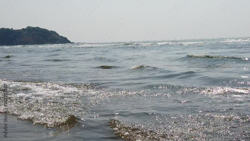 Foamy sea waves on shore. Foamy waves of clean sea water rolling on wet sandy beach on sunny day on resort Foamy sea waves on shore. Foamy waves of clean sea water rolling on wet sandy beach on sunny day on resort