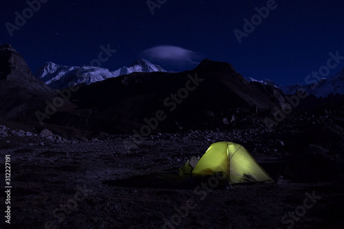 Himalayas, Nepal. A lonely tent at night in the middle of mountain peaks.