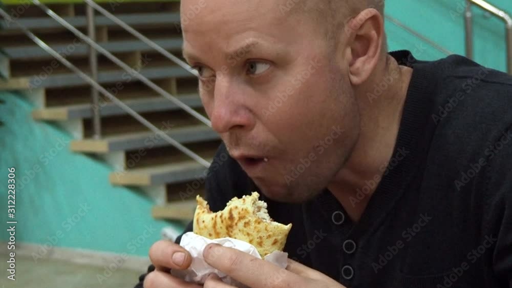 Young man eating fast food fried pancake in shopping center in fast food point close-up. The concept of a quick snack in a cafe. Modern nutrition is harmful to health. poor diet for weight gain Young man eating fast food fried pancake in shopping center in fast food point close-up. The concept of a quick snack in a cafe. Modern nutrition is harmful to health. poor diet for weight gain