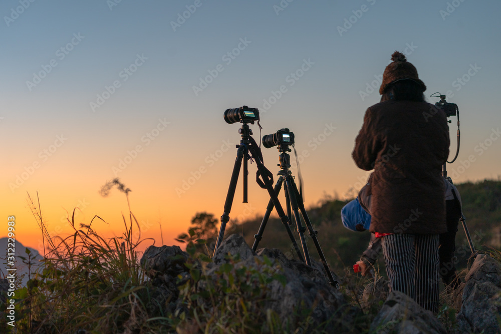 Photographers set up cameras to take pictures at sunrise.
