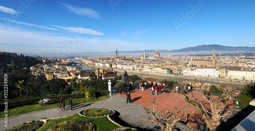 Florence, December 2019: Tourists admire th beautiful Skyline of Florence City from Piazzale Michelangelo with The famous Cathedral of Santa Maria del Fiore. Italy